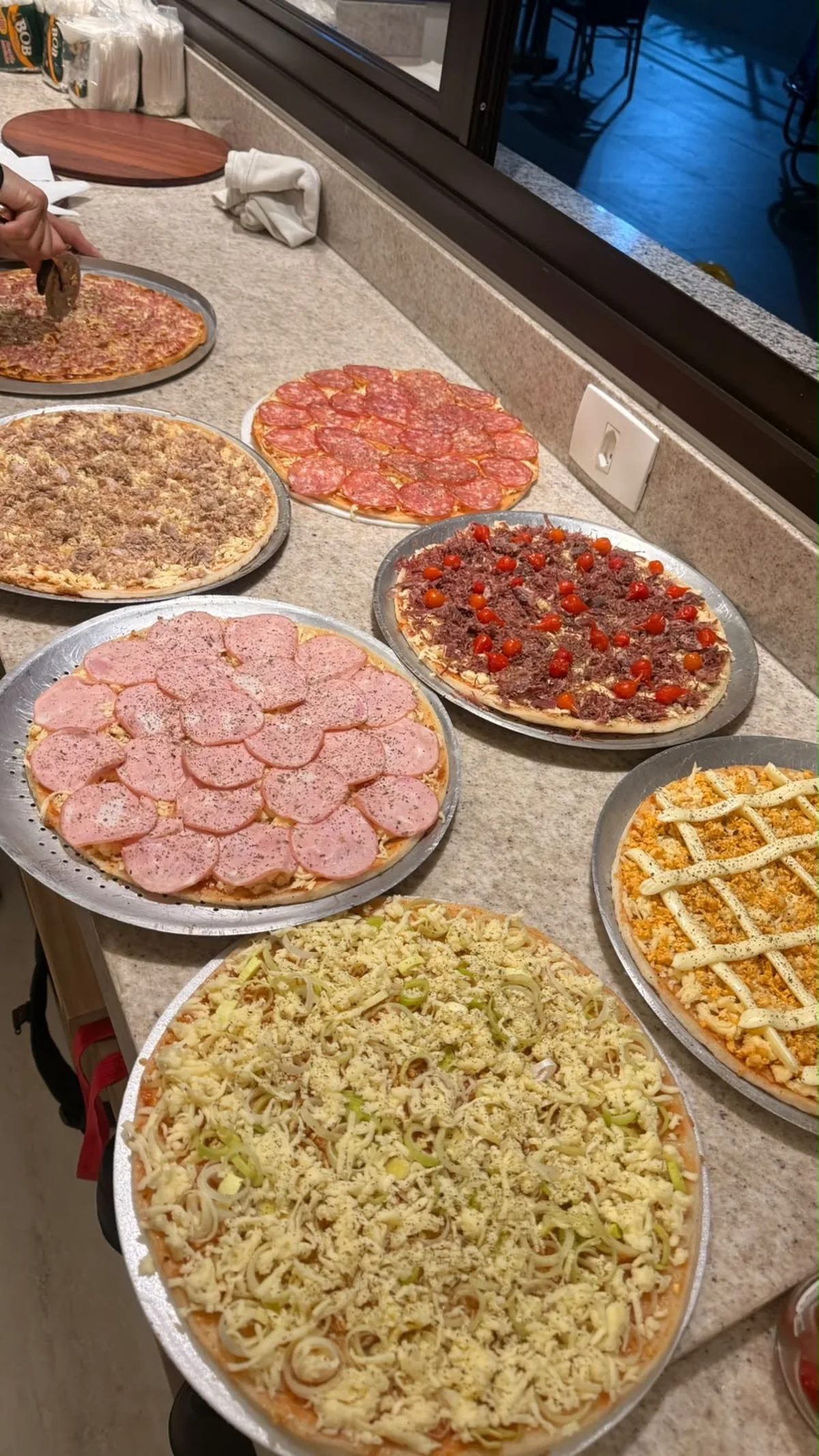 Pizzas sendo preparadas na cozinha do cliente