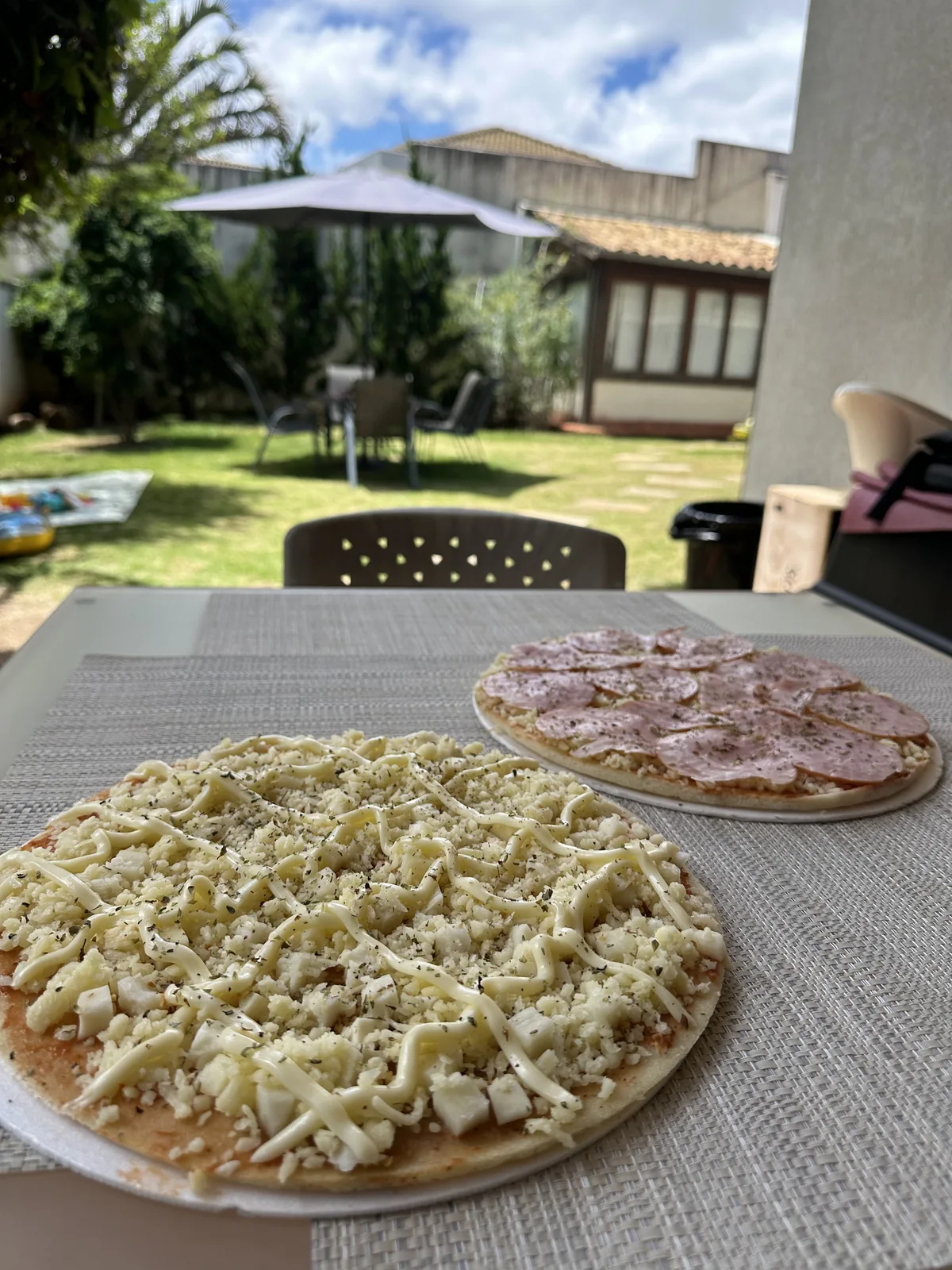 Pizzas preparadas no quintal residencial em tarde de sol